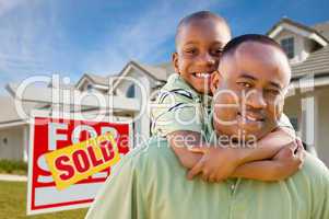 Father with Son In Front of Real Estate Sign and Home