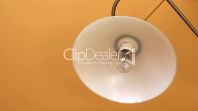 replacing old light bulb with new fluorescent light bulb