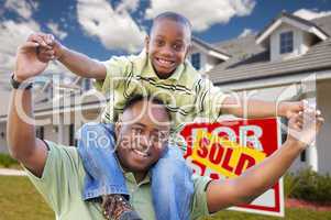 Father and Son In Front of Real Estate Sign and Home