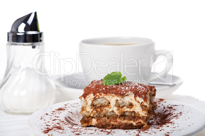 Tiramisu mit einer Tasse Kaffee und Zuckerstreuer