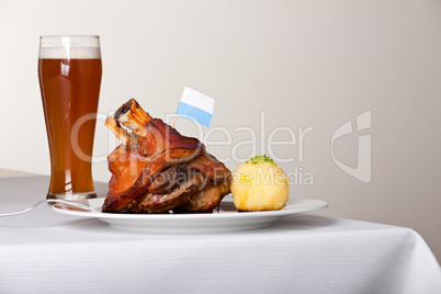 Schweinshaxe mit Kartoffelknödel auf einem Teller
