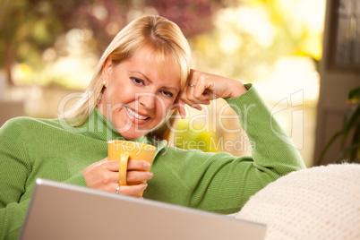 Beautiful Woman Enjoys Her Warm Drink and Laptop