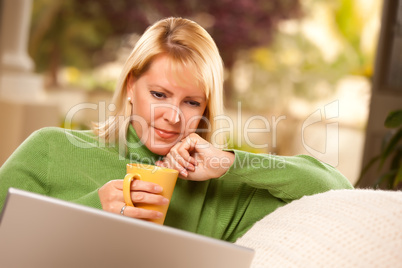 Beautiful Woman Enjoys Her Warm Drink and Laptop