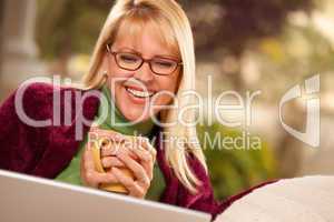 Beautiful Woman Enjoys Her Warm Drink and Laptop