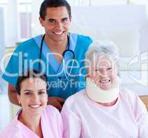 Two smiling doctors taking care of an injured senior woman