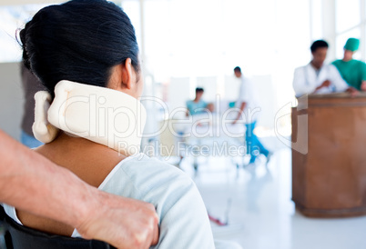 Brunette woman with a neckbrace sitting on wheelchair