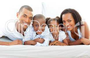 Happy family having fun lying down on bed