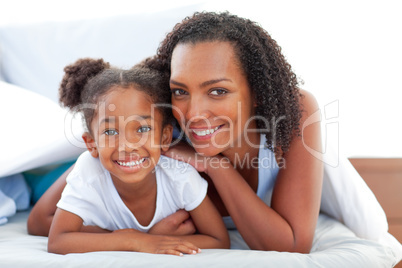 Affectionate woman and her daughter relaxing lying down on bed