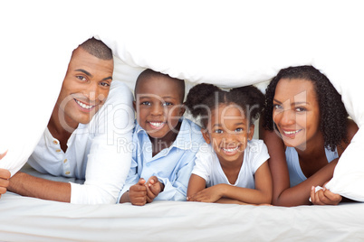 Merry family having fun lying down on bed