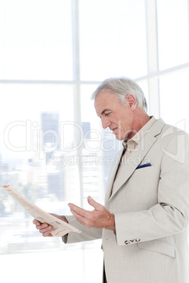 Portrait of a senior manager reading newspaper