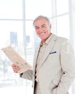 Portrait of a smiling manager reading newspaper