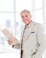 Portrait of a smiling manager reading newspaper