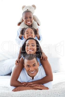 Blissful family having fun lying down on bed