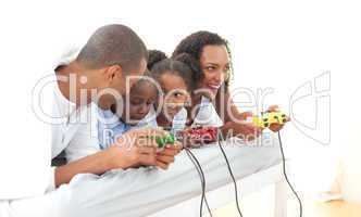 Lively family playing video game lying down on bed