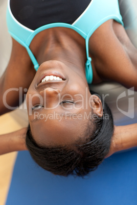 Smiling ethnic woman working out with a pilates ball
