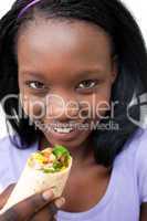 Charming young woman eating a wrap