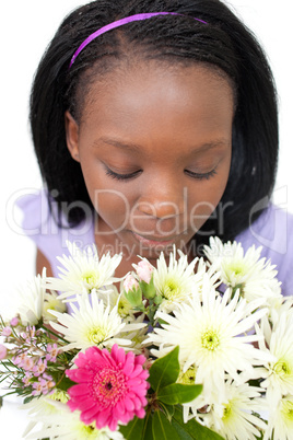Charming young woman smelling flowers