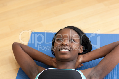 Smiling woman in gym clothes doing sit-ups