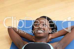 Smiling woman in gym clothes doing sit-ups