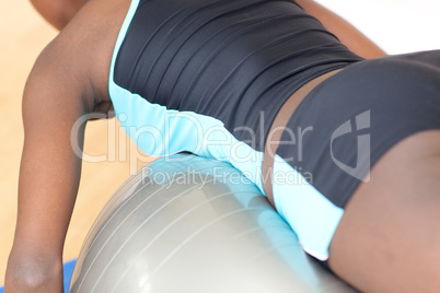 Young woman doing push-ups with a gym ball