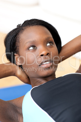 Ethniic woman in gym outfit doing sit-ups