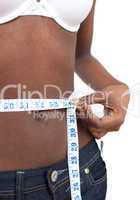 Ethnic woman measuring her waist with a tape measure