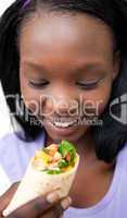 Delighted woman eating a wrap