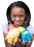Smiling ethnic woman showing Easter eggs