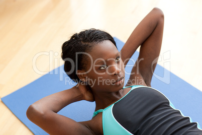 Young ethnic woman in gym clothes working out
