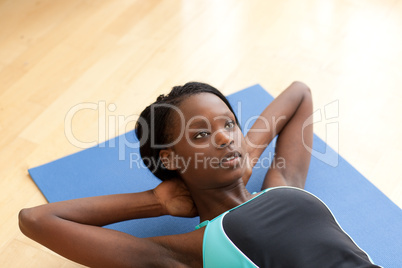 Charming woman in gym clothes doing sit-ups