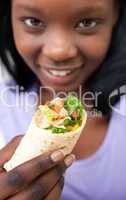 Attractive Afro-american woman eating a wrap