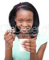 Smiling Afro-american woman eating a yogurt
