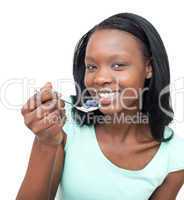 Smiling woman eating a yogurt with blueberries