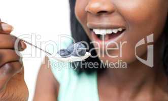 Close-up of a woman eating a yogurt with blueberries