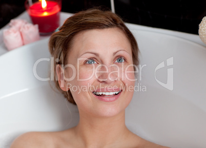 Joyful woman relaxing in a bath