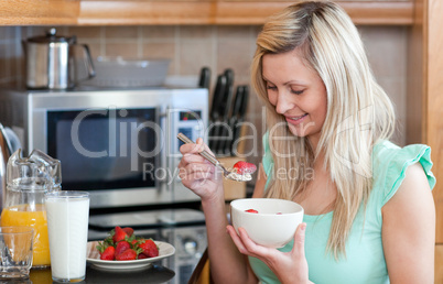 Jolly woman having an healthy breakfast in a kitchen