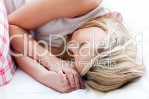 Blond young woman sleeping on a bed