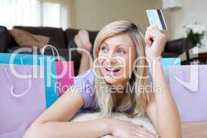 Joyful woman holding a credit card after shopping