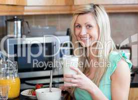 Smiling woman having an healthy breakfast in a kitchen