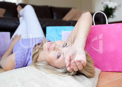 Tired young woman after shopping lying on the floor
