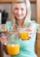 Young woman holding a glass of orange juice while having an heal