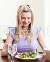Happy young woman eating a salad