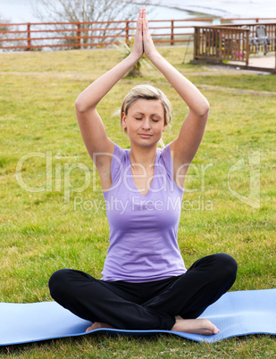 Relaxed woman doing yoga sitting on the grass