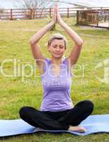 Relaxed woman doing yoga sitting on the grass