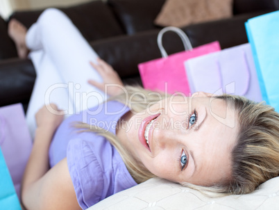 Happy woman after shopping lying on the floor