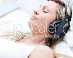 Attractive woman with headphones on sleeping on a bed