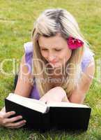 Charming woman reading a book in a park
