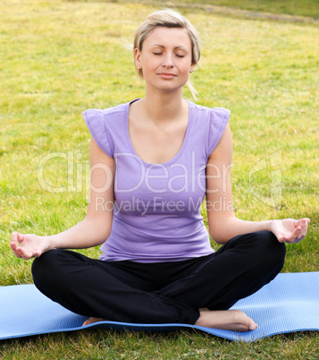 Concentrated woman meditating in a park