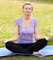 Concentrated woman meditating in a park