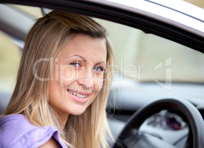 Jolly young female driver sitting in her car